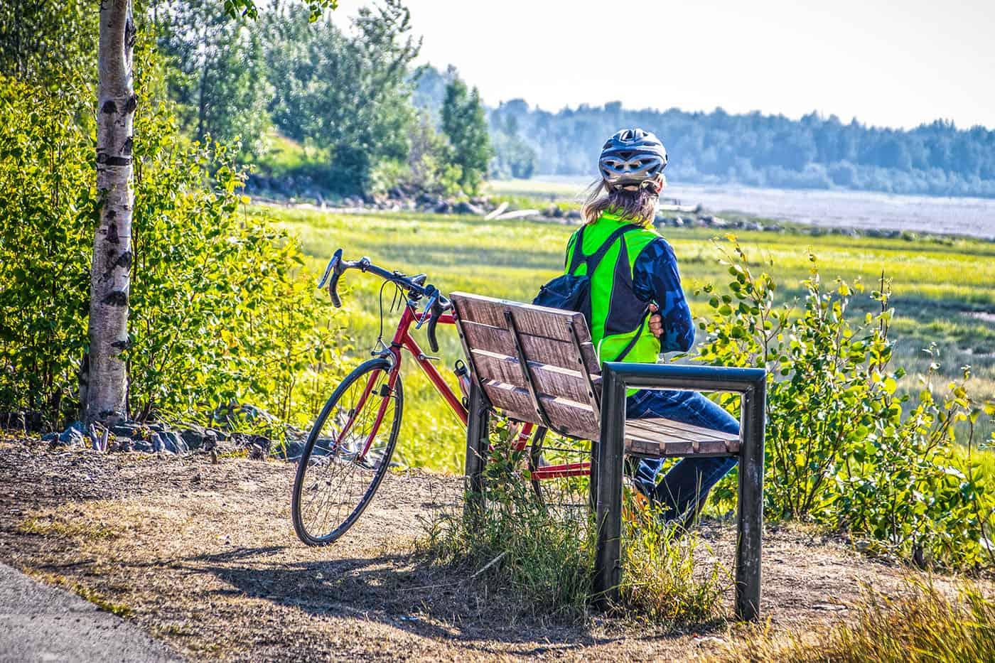person sitting on a bench next to their bike